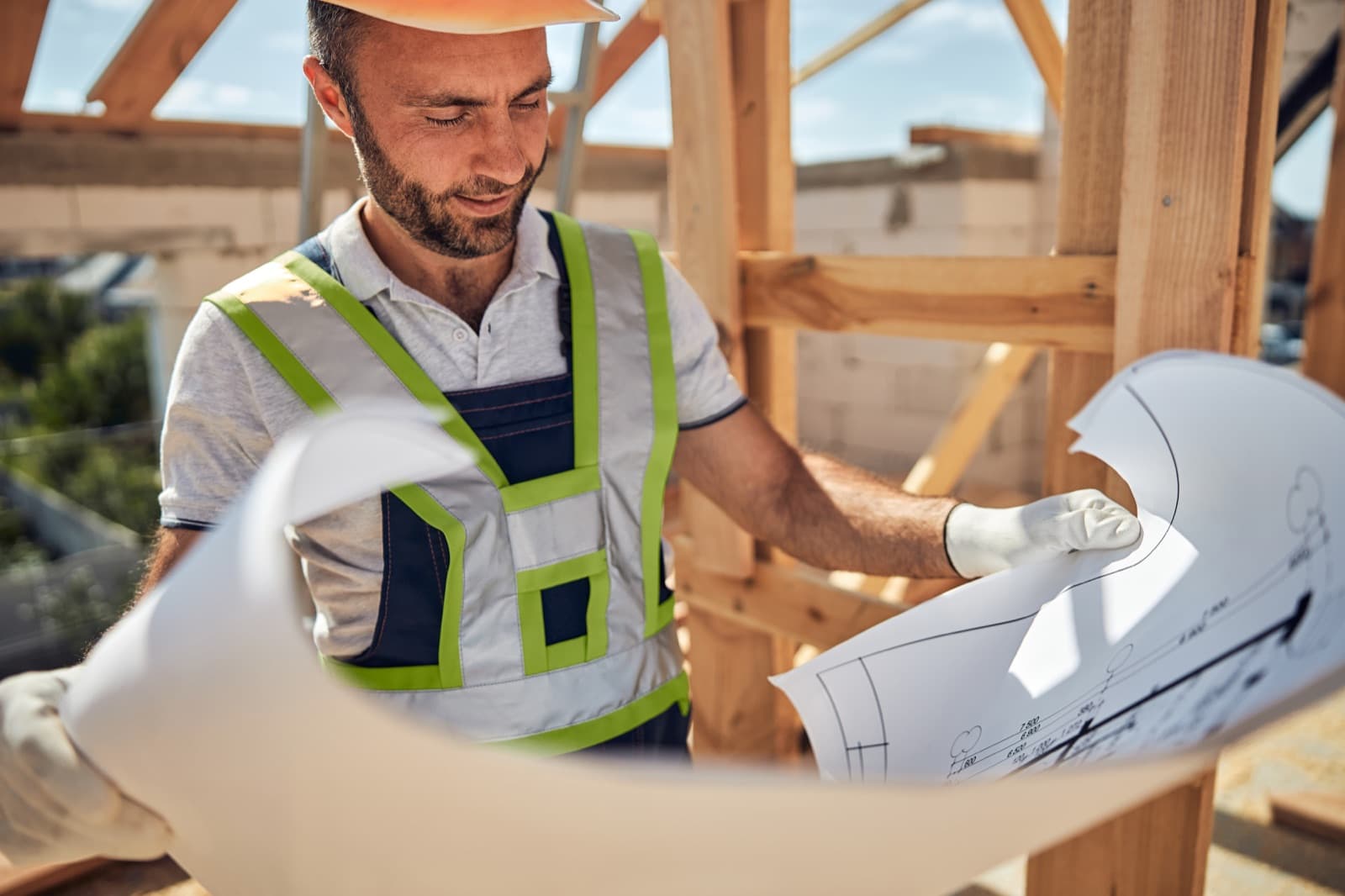 General contractor reviewing blueprints on a residential job site